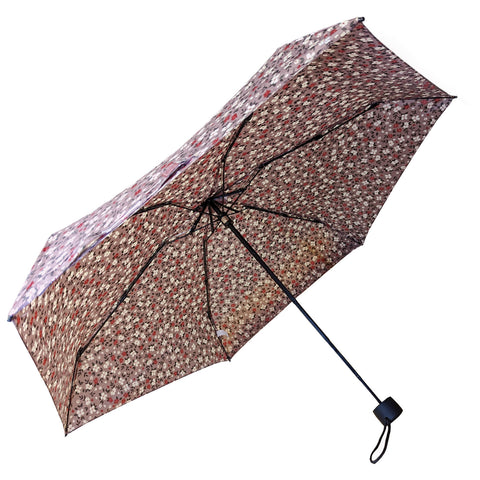 A patterned umbrella is opened showcasing a floral design with small colorful elements while the surrounding context is a neutral background highlighting the umbrella's structure and decoration.