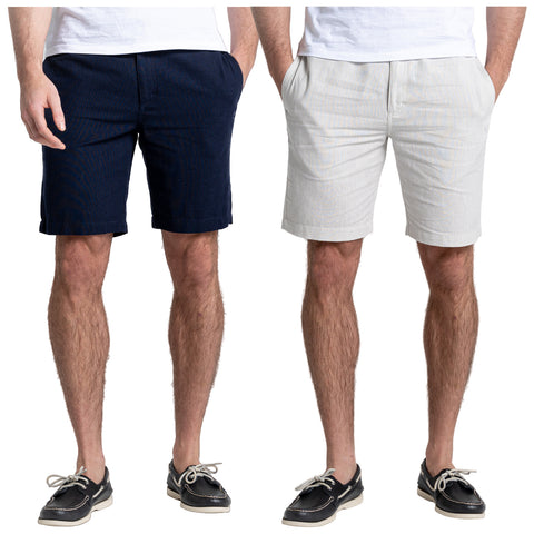 Two pairs of shorts are displayed side by side. The left pair is dark navy while the right is light gray. Both are worn by a man standing casually.