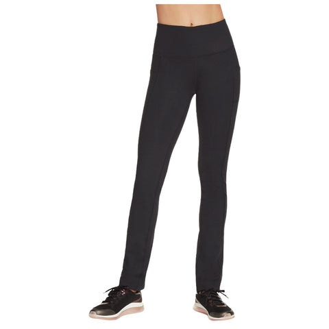 Leggings are worn by a person standing upright focused on fitness the outfit is black with a high waistband paired with athletic shoes in a casual indoor setting.