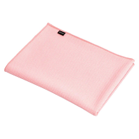 A pink polka-dotted blanket is folded neatly on a flat surface showing texture and color with a small brand label visible on one edge.