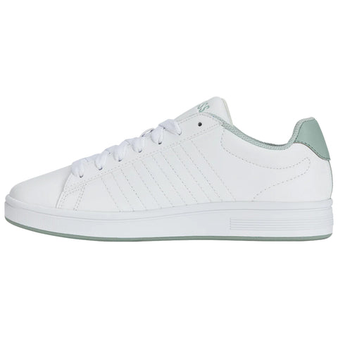 White sneaker with light green accents sits on a flat surface showcasing a simple design smooth material and lace-up closure surrounded by a neutral background