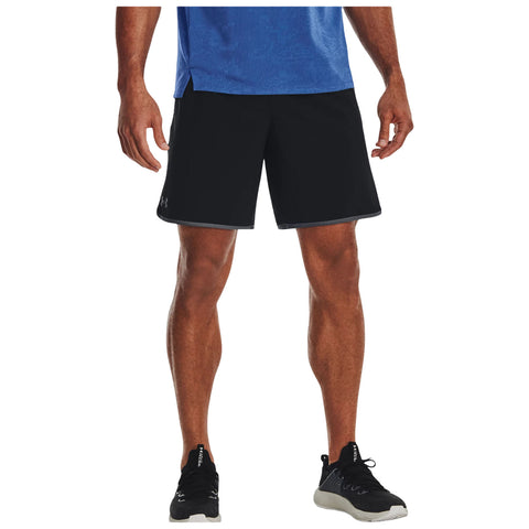 Black athletic shorts are worn by a person standing in a relaxed pose with a blue shirt and black athletic shoes on a neutral background.