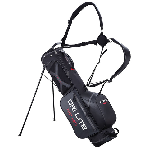 A black golf bag with adjustable straps stands upright on four legs. It features multiple compartments for clubs and gear with visible branding, designed for easy carrying on the course.