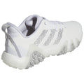 A white athletic shoe with a textured upper and a rugged sole sits on a flat surface showcasing its design features such as three stripes and a reinforced heel for support.