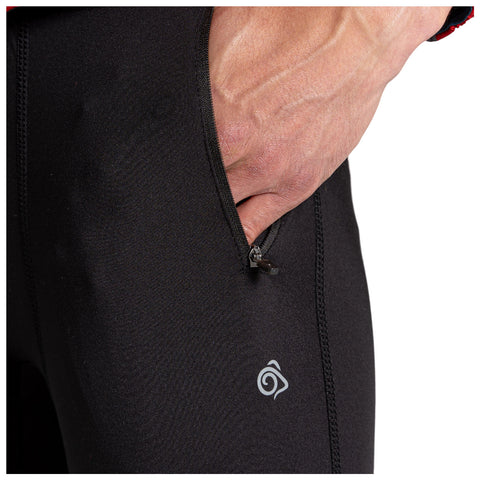 A hand is placed inside a zippered pocket of black athletic pants featuring a small logo on the lower leg showcasing a sleek and functional design without visible background elements.