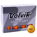 A box of golf balls labeled Volvik Power Soft sits prominently with a single yellow golf ball in front, showcasing its textured surface and distinct numbering.