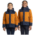 Two children are smiling while wearing matching stylish jackets featuring orange and navy colors with hoods standing against a plain white background. The girl is on the left and the boy is on the right.