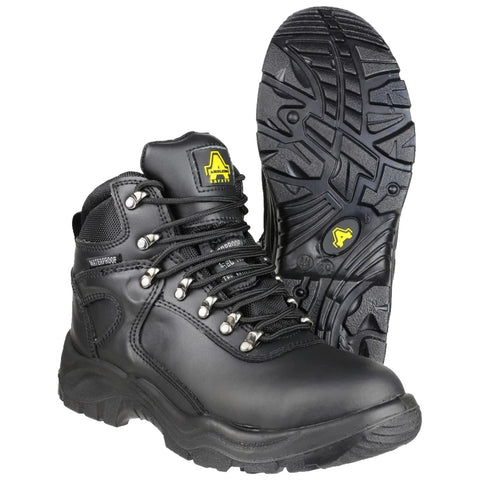 Black waterproof boots with a sturdy sole are positioned upright one in front of the other showcasing metal eyelets and laces designed for outdoor or work environments.