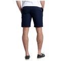 A person is standing with their back facing the viewer wearing dark blue shorts and black shoes. The setting appears casual and relaxed, suggesting outdoor or warm weather attire.