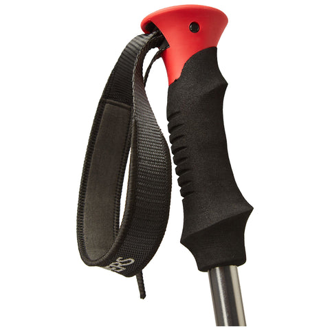 A hiking pole features a black textured grip and red top with an attached black strap. It is positioned against a plain background, emphasizing its design and functionality.