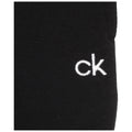 A black sock sits prominently with the letters "ck" embroidered in white on its side, highlighting a simple yet recognizable brand design in a plain background.