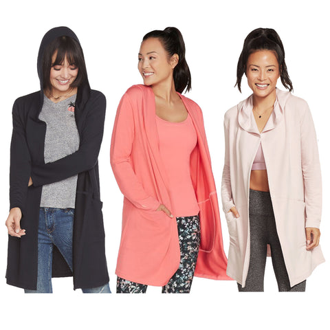 Three women are wearing different colored cardigans over casual outfits. They are smiling and posing against a plain white background, showcasing the variety of styles and colors in the cardigans.