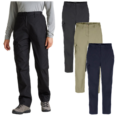 A person stands wearing black pants while three additional pairs of pants in black grey khaki and navy are displayed nearby showcasing a versatile clothing option for outdoor activities.