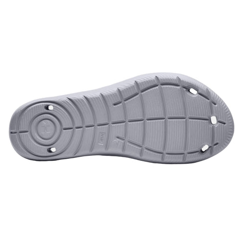 A gray shoe sole is displayed flat with visible tread patterns and a circular design in the center showing signs of wear indicating its use on various surfaces.