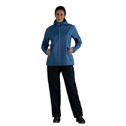 A woman stands confidently wearing a blue waterproof jacket and black pants with hands in pockets against a plain white background suggesting a casual outdoor apparel look.