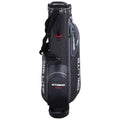 A black golf bag stands upright with a padded strap for carrying. It features multiple compartments for storage and is designed for durability and weather resistance.