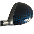 A golf club head is shown resting horizontally with a shiny blue and black patterned surface reflecting light in a simple background emphasizing its sleek design and modern look.