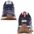 Athletic shoes are positioned to showcase their design with laces and branding visible the shoes are dark blue with a white and red accent featuring a textured sole suitable for various surfaces.