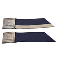 Two navy blue fabric belts are displayed horizontally with metal buckles showcasing the Under Armour logo each belt has a cream-colored stripe running along one side against a plain background.