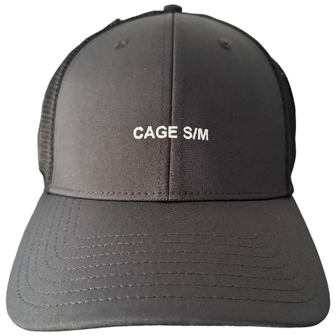 A black cap with a curved brim displays the text CAGE S/M in white on the front. The fabric has a smooth texture with mesh sides for ventilation.