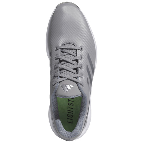 Gray athletic shoe with a textured upper and white sole rests flat on a surface showcasing its sleek design and lacing system with green insole displaying the word LIGHTST.