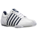 A white athletic shoe sits on a flat surface featuring navy stripes along the side with laces threaded through loops and a logo on the tongue indicating its brand K-Swiss