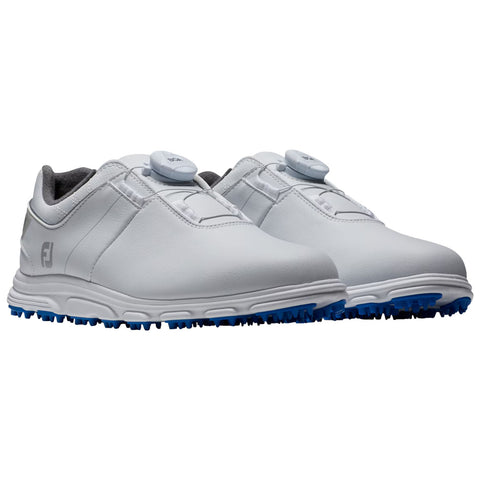 A pair of white golf shoes is displayed resting on a flat surface featuring a smooth upper material with a dial lacing system and blue spiked soles for traction.