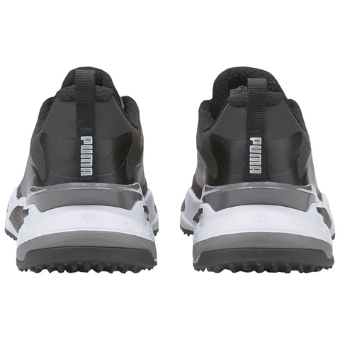 Black and gray athletic shoes are positioned upright with a white sole and textured grip bottom showcasing a sleek design suitable for sports or casual wear in an indoor setting.