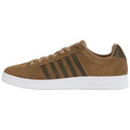 A tan sneaker with a suede texture features three dark green stripes on the side and beige laces with a thick white sole designed for casual wear.