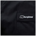 A black fabric garment displays a pocket with the white logo of the brand Berghaus prominently stitched on it, suggesting an outdoor or hiking apparel context.