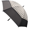 A decorative umbrella with a cream-colored canopy featuring green four-leaf clover patterns is open and positioned diagonally against a neutral background. Its handle is visibly extended.