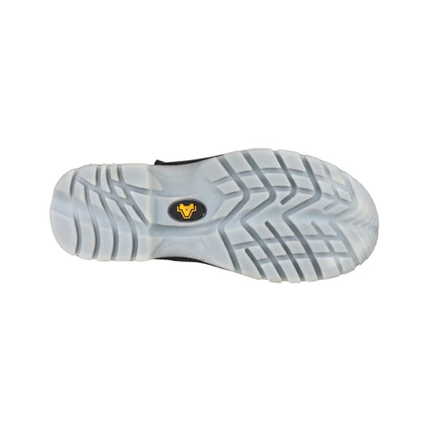 A black shoe sole with a patterned grip design rests flat against a plain background highlighting the tread and logo in the center which is yellow and black.