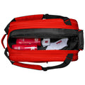 A red sports bag is open revealing two pink containers and a pair of white socks inside the black compartment showcasing a practical layout for storing sports equipment.