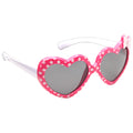 Heart-shaped sunglasses with a pink frame adorned with white polka dots are displayed against a light background showcasing a playful and whimsical accessory typically worn for sun protection.