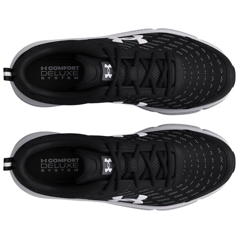 Black athletic shoes are positioned with the tops facing up showcasing a sleek design and perforated upper material with white logo details and text reading COMFORT DELUXE SYSTEM inside the shoes