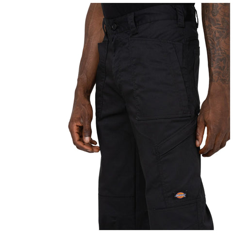 Black cargo pants are being worn by a person with a visible arm tattoo the pants feature multiple pockets and the logo of a brand on the side