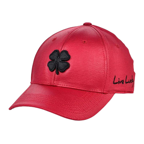 A vibrant red cap features a black four-leaf clover emblem on the front and the words Live Lucky embroidered on the side, suitable for casual wear or outdoor activities.