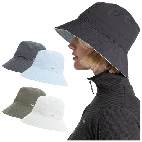 A woman wearing a black bucket hat is shown alongside three other bucket hats in gray light blue and white placed around her. She is wearing a black zippered top.