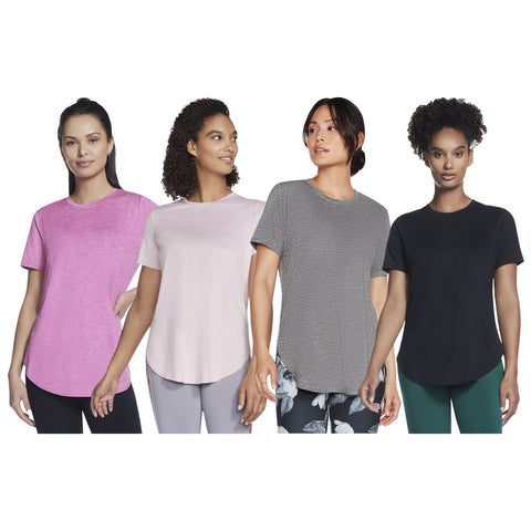 Four women are standing side by side wearing different colored t-shirts pink light pink gray and black showcasing casual athletic wear against a plain white background.