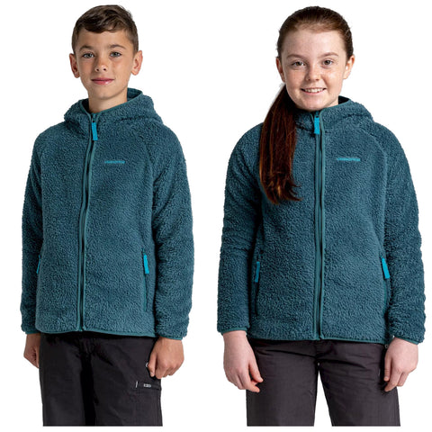 Two children stand side by side wearing matching teal fleece jackets with zipper fronts and hooded tops Their expressions are friendly with the boy smiling confidently and the girl beaming joyfully