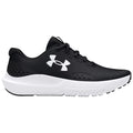 A black athletic shoe with a textured upper and white sole is positioned sideways showcasing its sleek design and brand logo in a minimalist, neutral background.