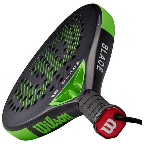 A black and green paddle racquet with a textured grip and logo is positioned diagonally, showcasing its design and perforated surface, suggesting uses in racquet sports.