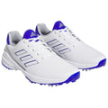 White athletic shoes with purple accents are displayed side by side showcasing a sleek design and distinct traction soles suitable for outdoor sports on various surfaces.