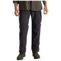 Black cargo pants feature zippered pockets and sections for zip-off legs creating shorts. Worn by a person standing with hands visible in a neutral outdoor setting.