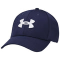 A navy blue baseball cap with a white logo on the front rests at an angle, showcasing its structured design and curved brim against a neutral background