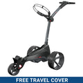 A black golf trolley with a sturdy handle and large wheels is positioned prominently. It features a holder for golf bags. The background includes a blue banner stating FREE TRAVEL COVER.