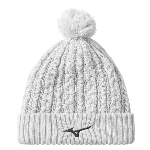 A knitted gray beanie with a pom-pom on top features a ribbed cuff and a black logo on the front. It is designed for warmth in cold weather.