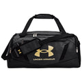 A black and gray duffel bag is displayed with a prominent gold Under Armour logo on the front the bag features dual handles and an adjustable shoulder strap positioned for easy carrying.