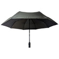 A black umbrella is opened wide with a sturdy handle underneath providing shelter from rain or sun in an unspecified outdoor environment.