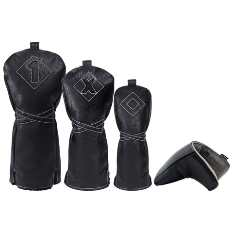 Three black leather golf headcovers with numbers 1 and symbols X and O are positioned upright with a fourth smaller headcover lying on its side. They are designed for club protection.